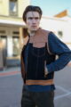 Model wearing the OVLAN denim and leather motorcycle vest, featuring tan quilted leather shoulders and denim body, blending functionality and style for riders.