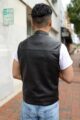 The back view of the OVLAN black leather motorcycle vest, showcasing the premium satin lining with the OVLAN logo and 