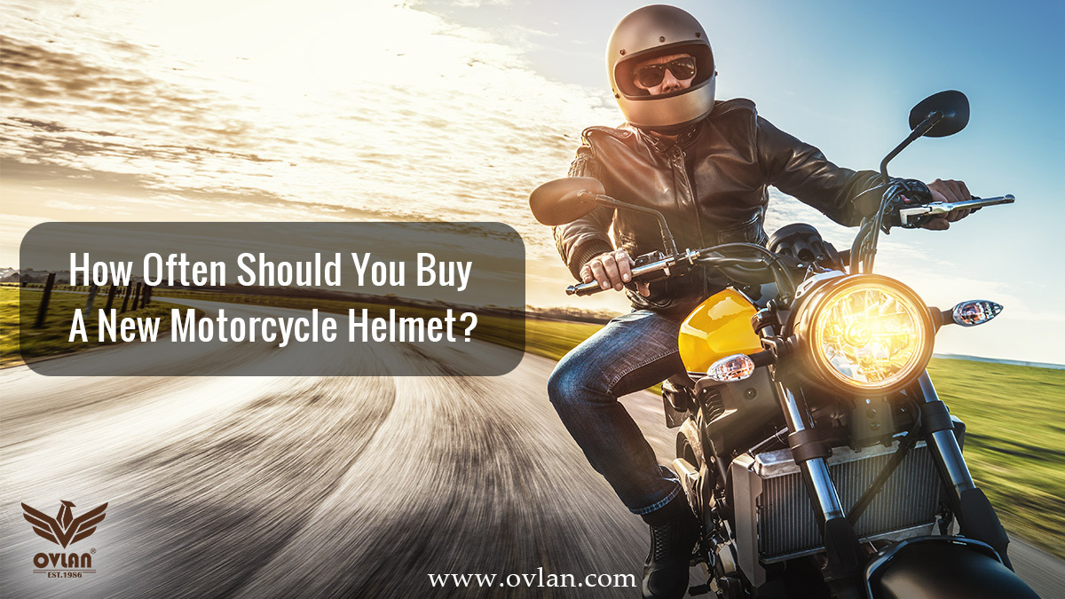 A motorcyclist riding with a helmet and leather jacket, with the text "How Often Should You Buy A New Motorcycle Helmet?"