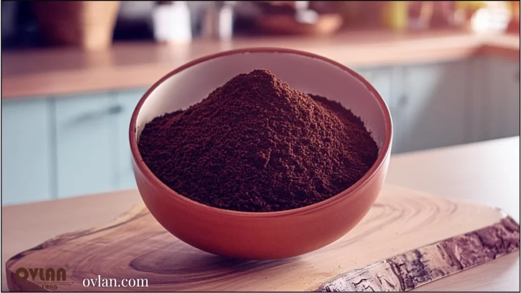 A bowl filled with finely ground coffee on a wooden surface.